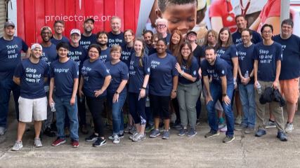 The BrandExtract team standing against a Project C.U.R.E. trailer.