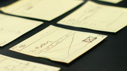 Sticky notes laid out with wireframes drawn on them
