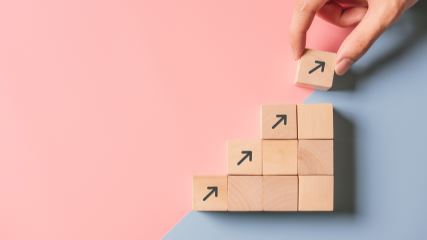 Staircase of building blocks with arrows leading towards the top