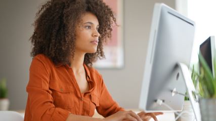 Woman typing on a desktop computer