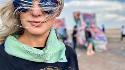 A close-up image of Catherine wearing sunglasses outdoors