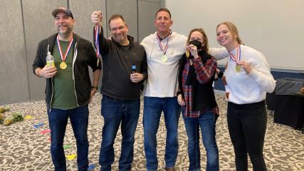 Jason, Malcolm, Bo, Rose and Lilli wearing gold medals after winning a company bowling competition