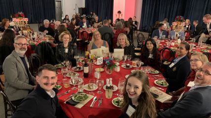 A group of ten BrandExtract employees sitting around a large round table at the Lantern Awards gala