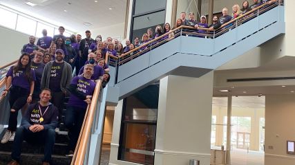 Entire BE team standing together on a staircase