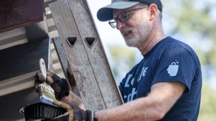 Jonathan painting a building at Special CHEERS
