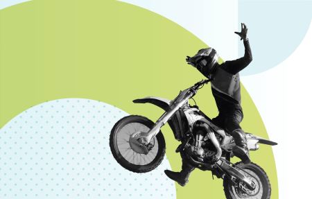 Photograph of a dirt biker with his arms outstretched to the sides, flying over a branded background with geometric light green and blue shapes