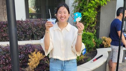 Holly wearing a cream colored shirt holding up a cup of ice cream and a popsicle at the Southern Ice Cream photo shoot