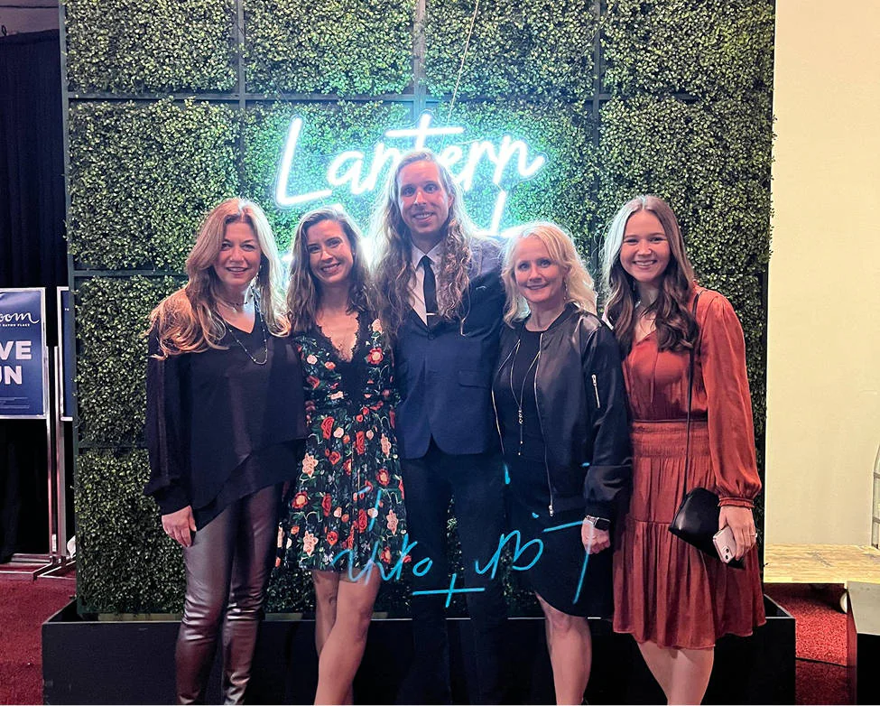 The BrandExtract team posing in front of the 2024 neon Lantern Awards sign