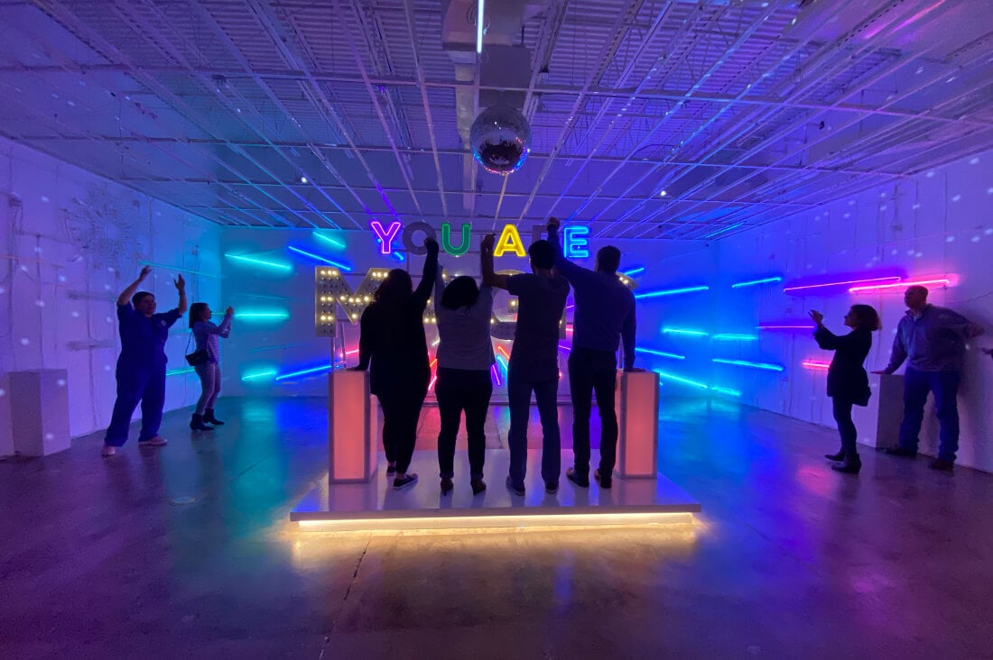 The BrandExtract team inside a neon art room