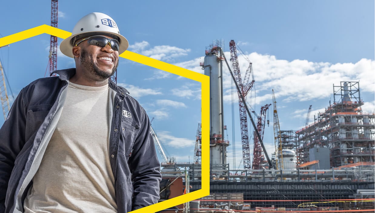 A S&B Employee shown smiling with a refinery in the background