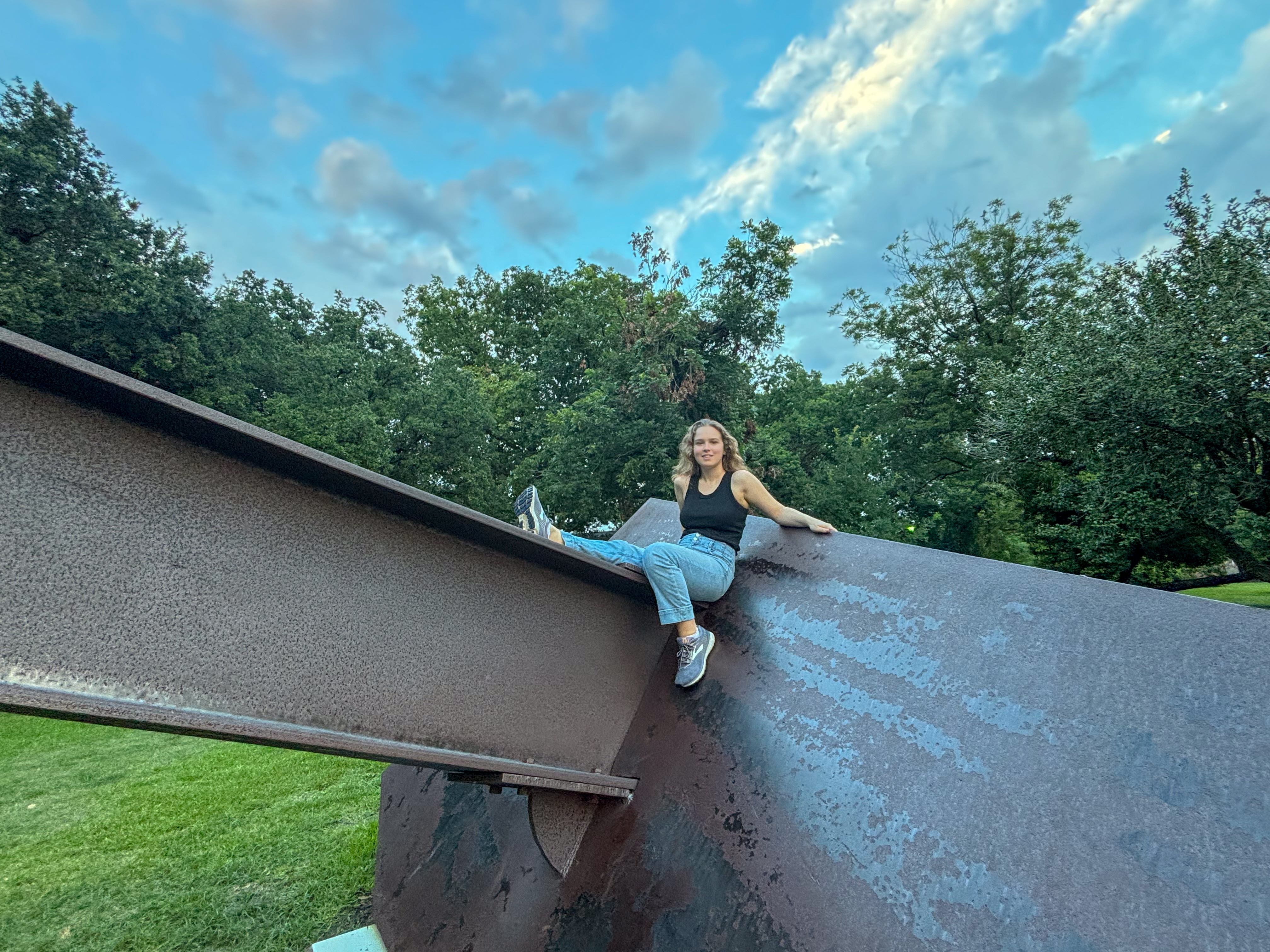 Ylliana leaning on a metal structure outside in the summer