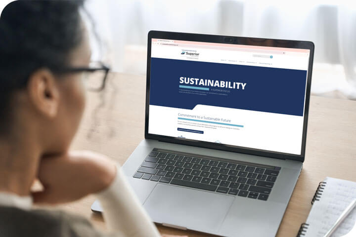 A person on a laptop looking at the Superior Sustainability website.